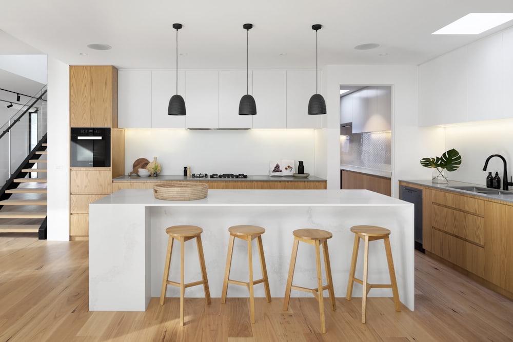 Kitchen with white oak cabinetry and black pendant lights